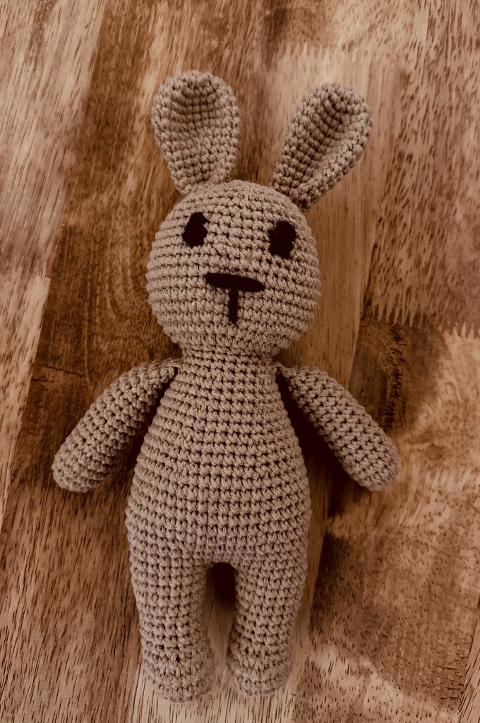 Handcrafted soft plush bunny on wooden surface